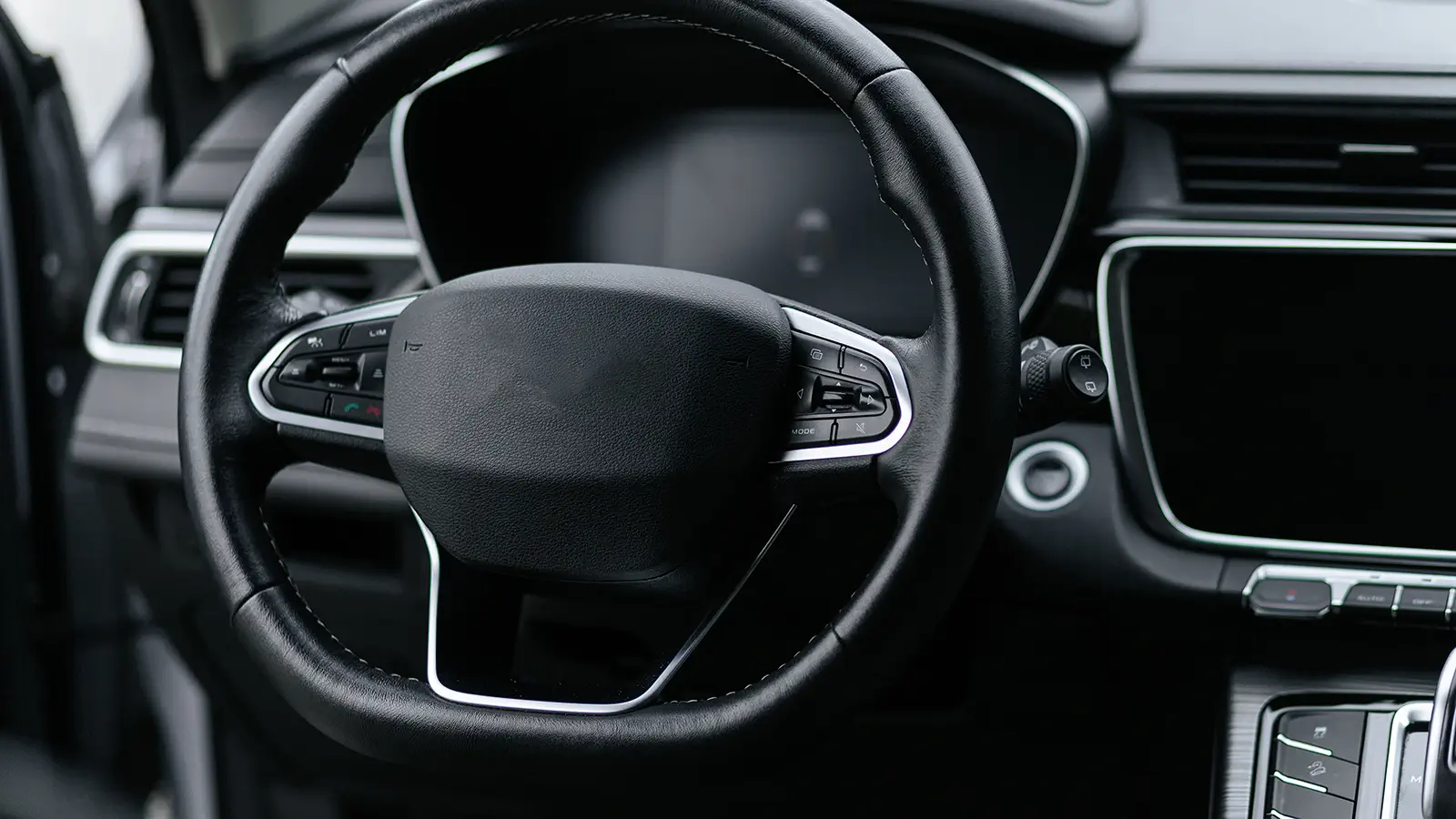 Modern Chinese vehicle interior — leather steering wheel with controls and a digital infotainment screen, fitted by Radio Waves, Gqeberha