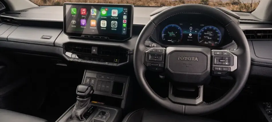 Toyota Hilux double cab dashboard showing the factory touchscreen with Apple CarPlay, digital instrument cluster and steering wheel controls